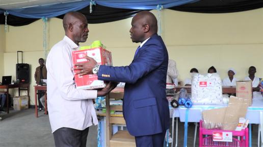 Un bénéficiaire recevant du représentant du Ministre provincial de la santé un kit de matériels de coupe et couture